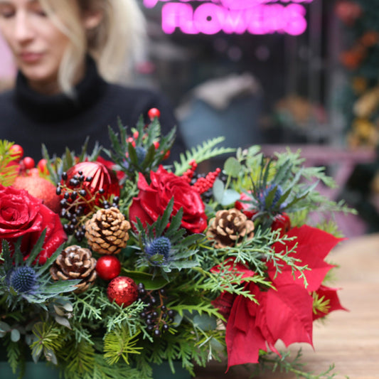 Luxurious holiday floral arrangement with white blooms and natural accents, ideal for Christmas table decor