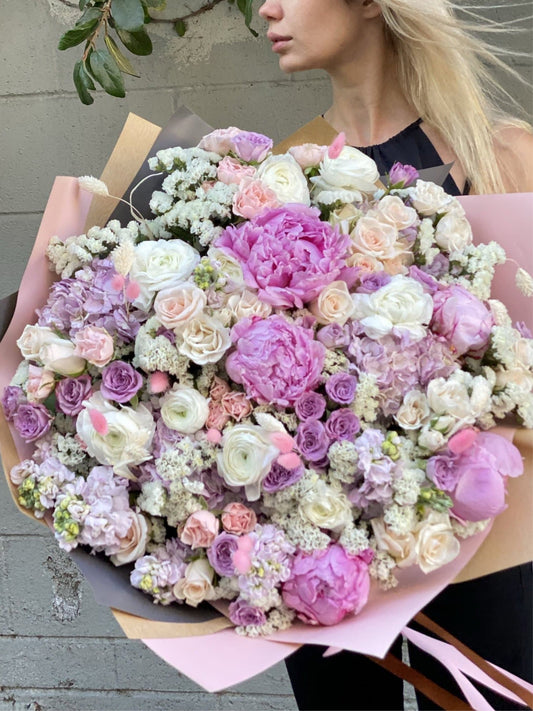 Elegant Milana bouquet featuring peonies, garden roses and greenery in a clear glass vase – ideal for premium floral delivery and romantic occasions
