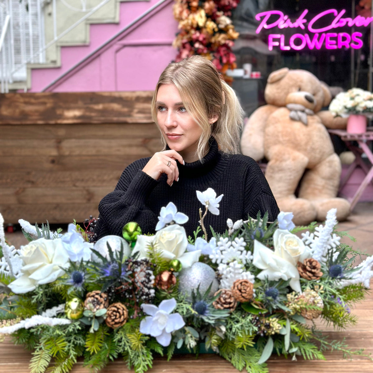 Festive holiday bouquet with white blooms and natural pinecones, arranged in a modern, celebratory style