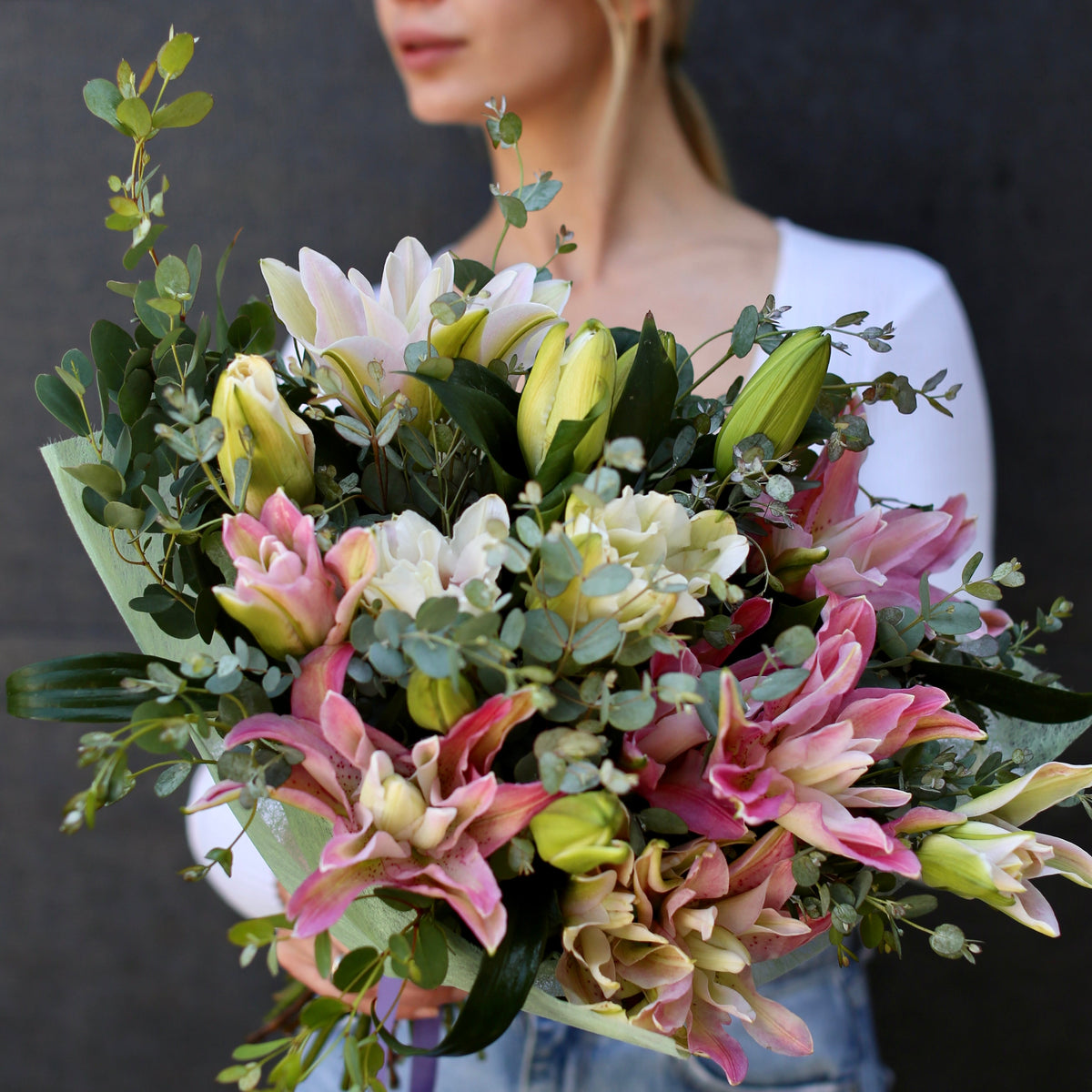 Elegant white lilies bouquet with roses and greenery, beautifully wrapped for a premium gifting experience