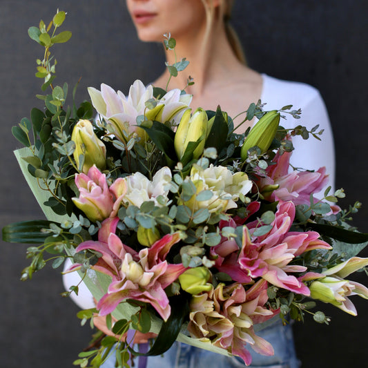Elegant white lilies bouquet with roses and greenery, beautifully wrapped for a premium gifting experience