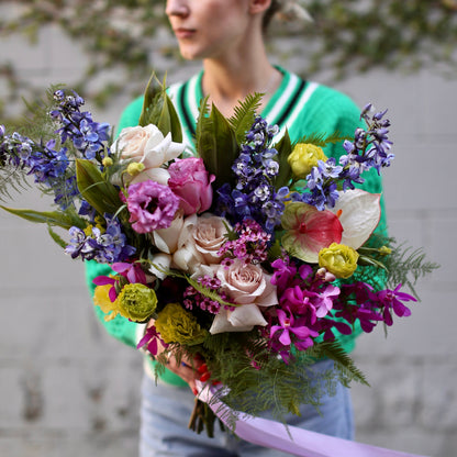Elegant floral bouquet with pink roses, carnations and greenery, beautifully wrapped for a soft and natural presentation
