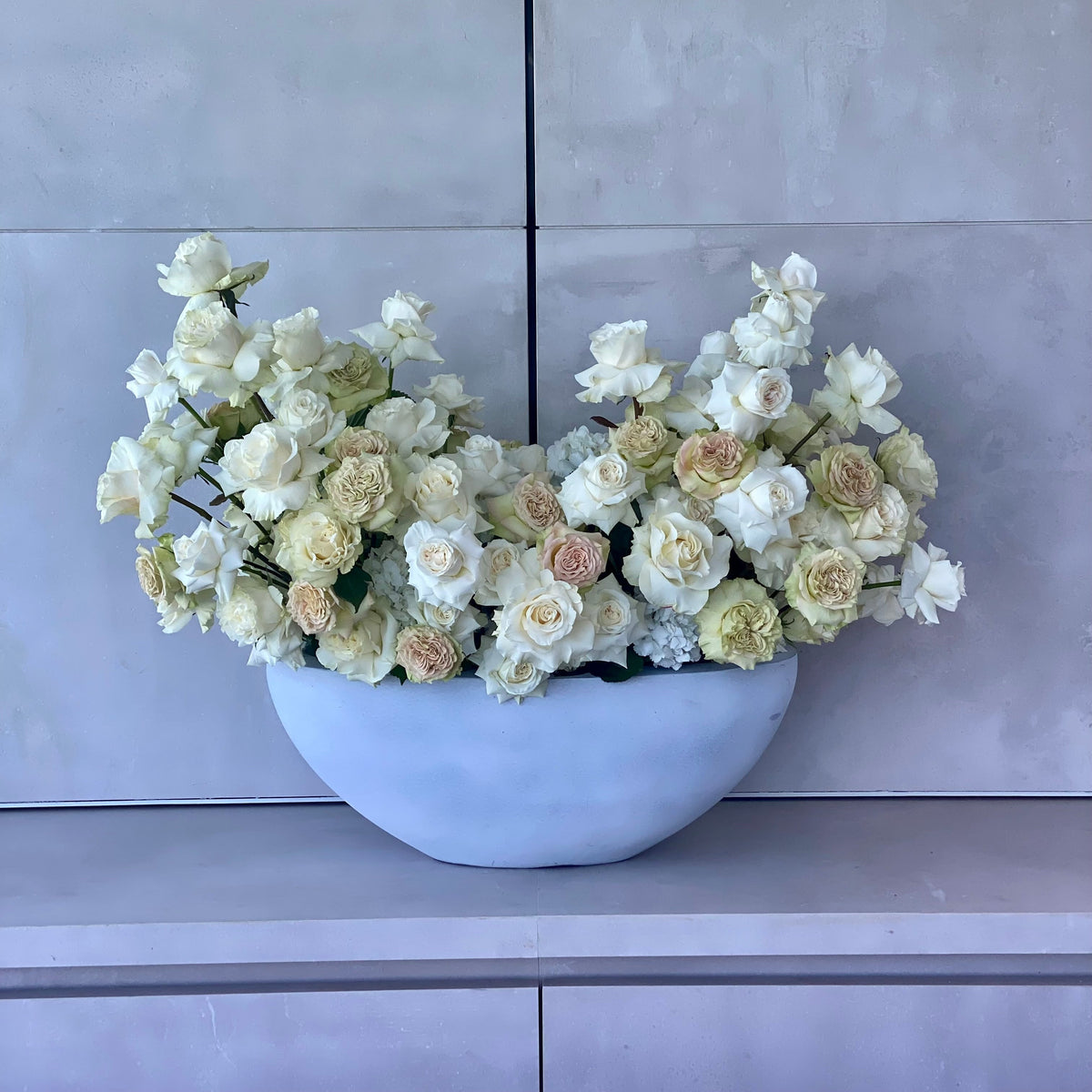 Elegant Majestic bouquet showcasing white and beige roses beautifully arranged in a modern gray vase for premium floral delivery