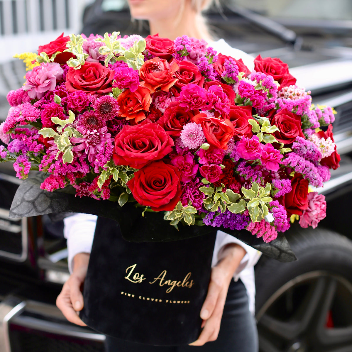 Premium flower gift showcasing fresh red roses, vibrant mix flowers and lush greenery in a refined boxed design