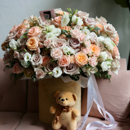 Fresh garden-style bouquet with textured blooms and lush foliage, beautifully presented in minimalist packaging.