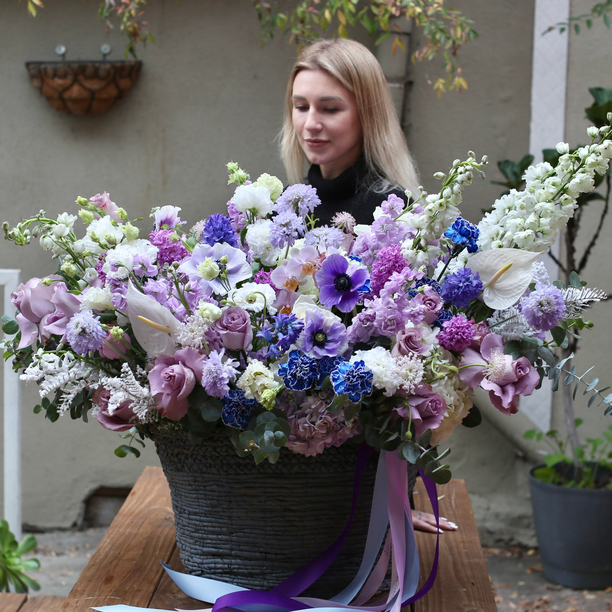 Luxurious Purple Passion floral arrangement featuring deep purple tulips, roses, and statice in a modern vase