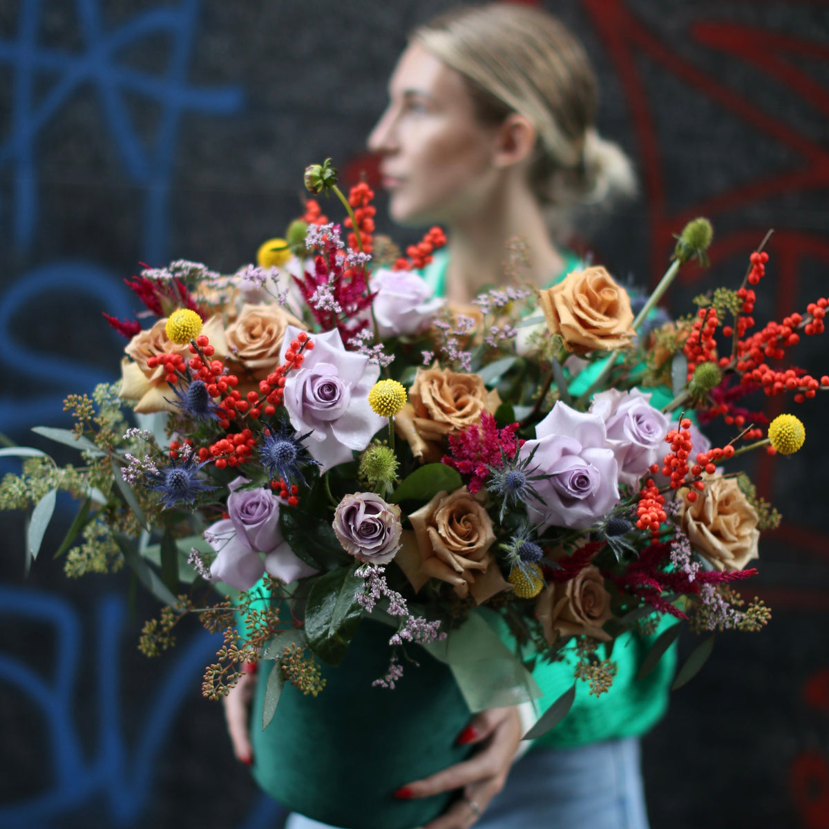 Richly colored fall bouquet with orange and burgundy flowers, elegantly styled for seasonal gifting