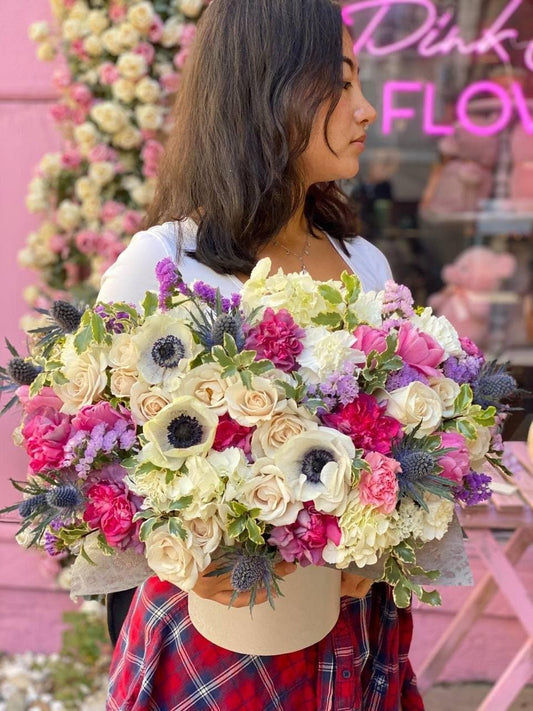Charming Loli floral arrangement featuring anemones, garden roses and dry berry accents in a round decorative box – ideal for premium gifting