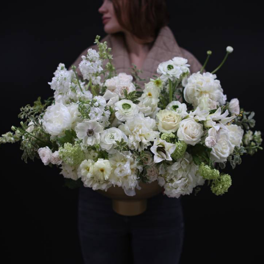 Elegant bouquet of white flowers with lush greenery, symbolizing purity and simplicity