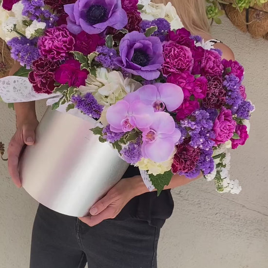 Luxurious floral arrangement with purple blooms and lush greenery, ideal for romantic occasions and upscale celebrations