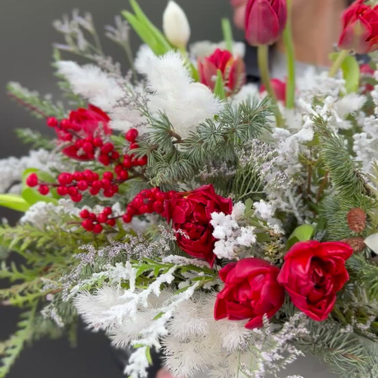 Handcrafted floral bouquet featuring white roses and lush greenery, ideal for winter celebrations